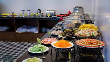 Un bufé con diversos platos, incluyendo ensaladas, carnes y verduras.