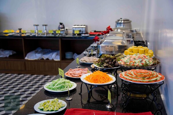 Un bufé con diversos platos, incluyendo ensaladas, carnes y verduras.
