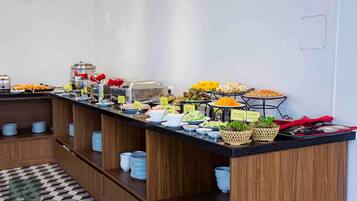 A buffet setup with various food items and labeled containers.