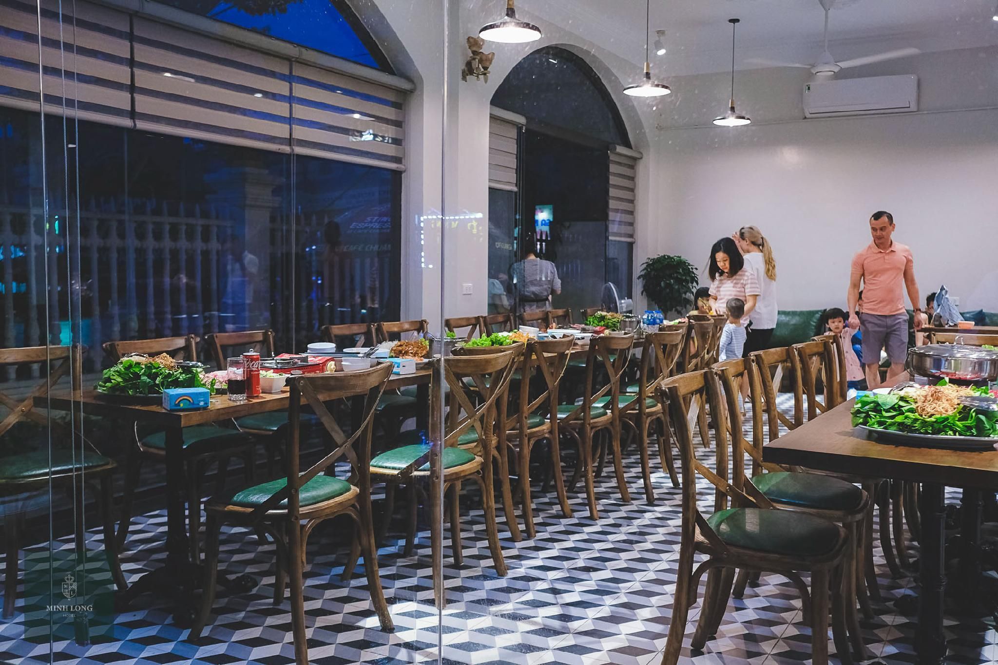 A restaurant with multiple tables, chairs, and a tiled floor.