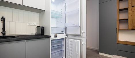 A modern kitchen with a built-in refrigerator, a sink, and a countertop.