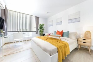 Une chambre moderne avec un lit, une table de chevet et un bureau avec des chaises.