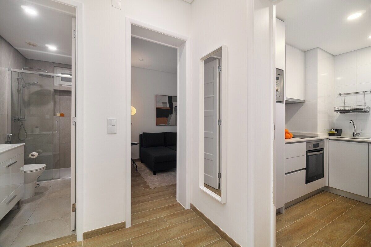 A modern apartment with a bathroom, kitchenette, and a living area.