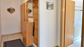 A hallway with a wooden wardrobe, a heart-shaped decoration, and a framed picture on the wall. - Baltique - Holiday apartment 5 Glowe - Holiday apartment Baltique 5 (Glowe)