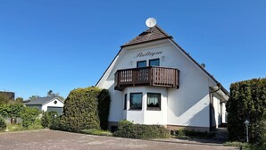 A two-story house with a balcony, a satellite dish, and a garage. - Baltique - Holiday apartment 4 Glowe - Holiday apartment Baltique 4 (Glowe)