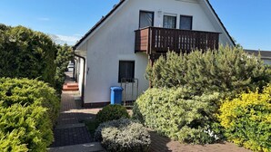 A modern two-story house with a sloped roof, a balcony, and a paved driveway. - Baltique - Holiday apartment 1 Glowe - Holiday apartment Baltique 1 (Glowe)