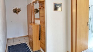 A hallway with a wooden wardrobe, a small mirror, a framed picture, and a door leading to a bathroom. - Baltique - Holiday apartment 1 Glowe - Holiday apartment Baltique 1 (Glowe)