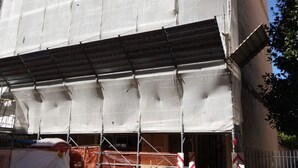Un bâtiment en construction, avec des échafaudages et du matériel de construction.