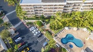 An aerial view of a hotel with a parking lot, a swimming pool, and surrounding greenery. - Maui Banyan Studio, King Bed, Steps to Kam2 Beach (Kihei)