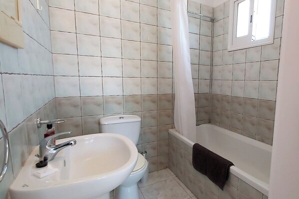 Een badkamer met een wastafel, toilet en bad.
