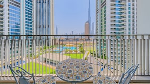 A balcony with a view of a modern cityscape, including tall buildings and a distinctive skyscraper. - Downtown Views Residences - Downtown DXB (Dubai)
