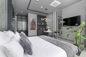 A modern bedroom with a large bed, bedside tables, a desk, and a TV. - West Baltic City (Szczecin)