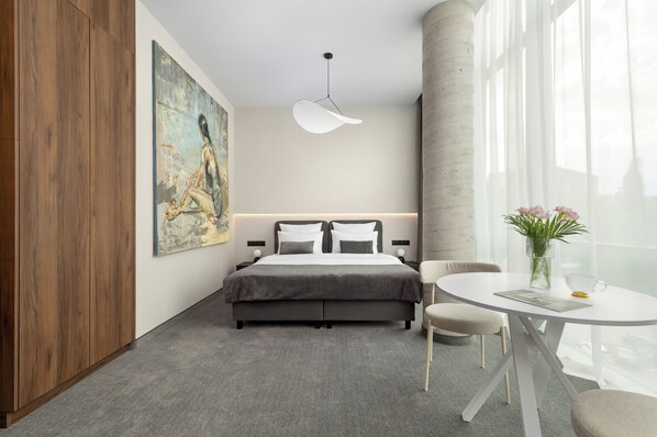 A modern hotel room with a bed, a dining table, and a large window. - West Baltic City (Szczecin)