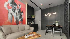 A modern living room with a sofa, coffee table, and a dining area with chairs and a table.