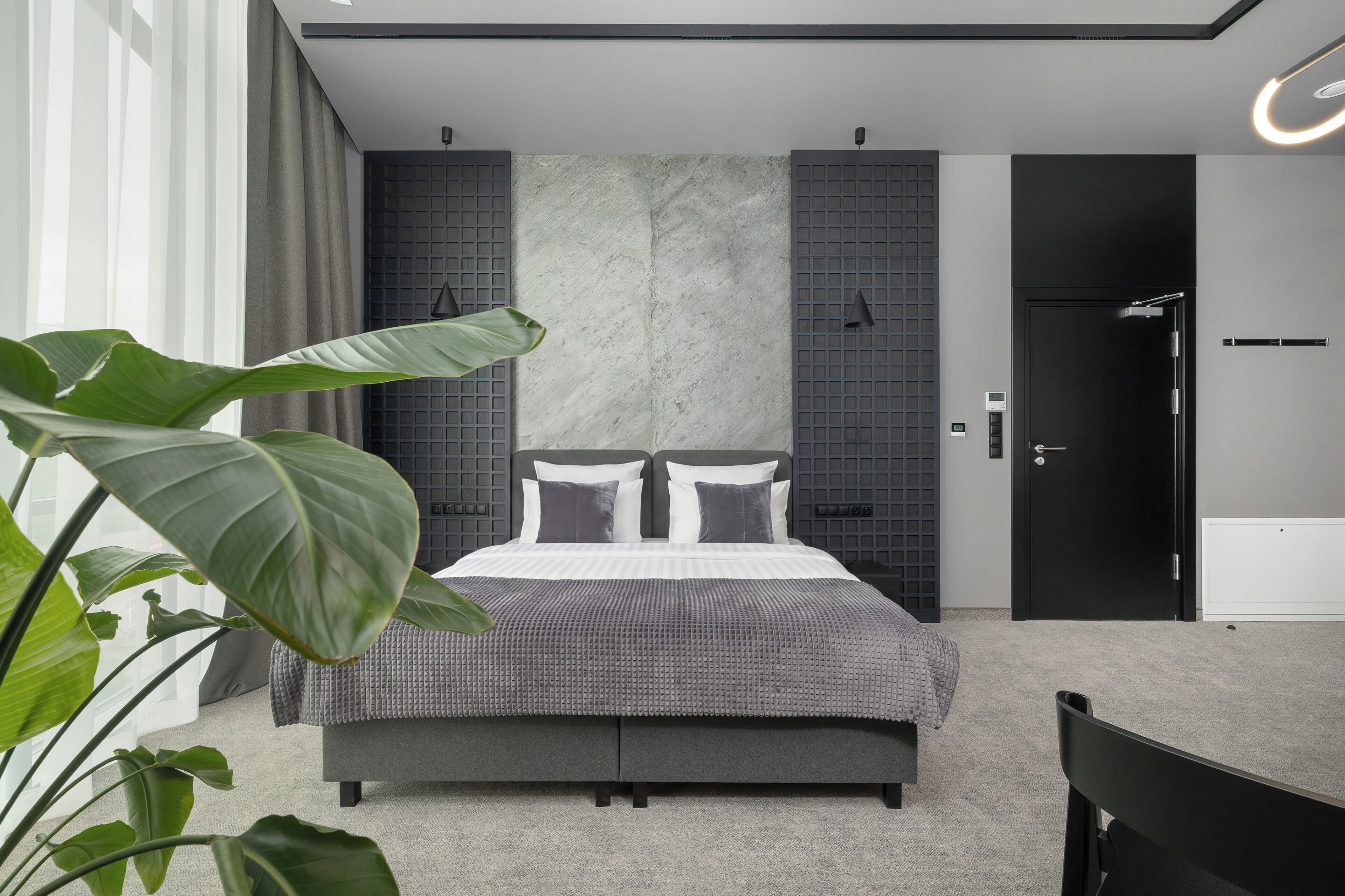 Une chambre à coucher moderne avec un lit, un bureau et une porte.