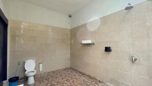 A bathroom with a toilet, a shower, and tiled walls. - The Lavana Bali Radiance Arjuna Villa Seminyak (Bali)