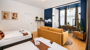 A hotel room with two beds, a sofa, a dining area, and a TV. - Wohnung mit schoenem Garten (Bielefeld)