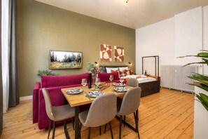 Una sala moderna con comedor, sofá, cama y radiador.