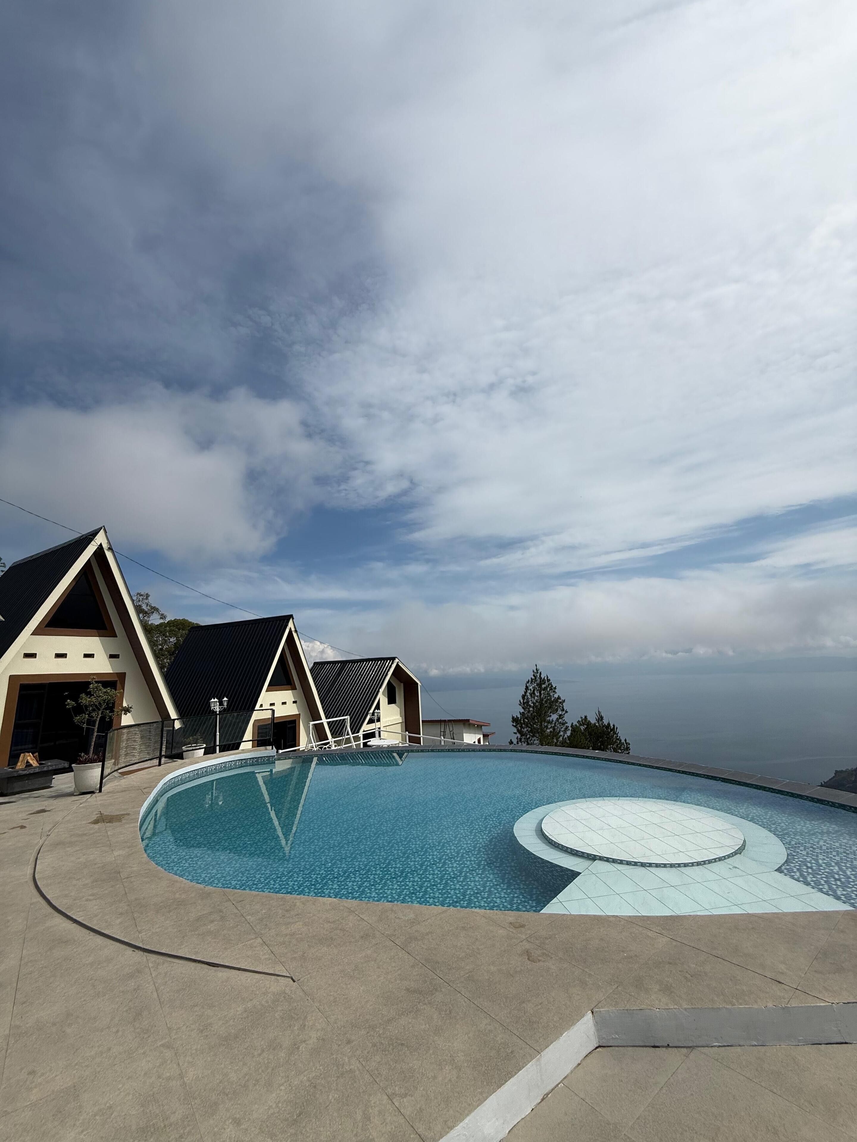A swimming pool with a unique design, surrounded by buildings with a modern architectural style.