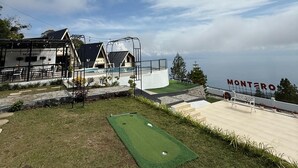 Un parcours de golf doté d’un green d’entraînement, d’une piscine et d’un bâtiment portant l’inscription « Montero ».