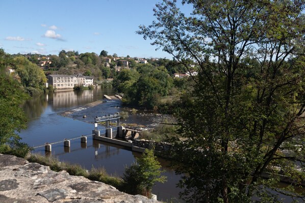 Une vue sur le fleuve, avec un quai, des bâtiments et des arbres.