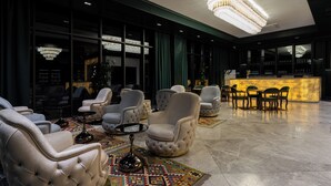 A spacious lobby with plush seating, a bar area, and a large chandelier. - Grand Dior (Tashkent)