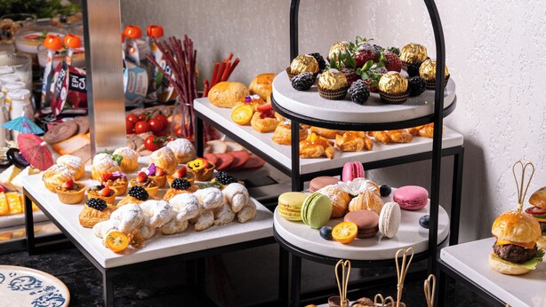 A buffet with various food items including sandwiches, pastries, and desserts. - Grand Dior (Tashkent)