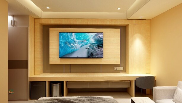 Una sala moderna con un televisor de pantalla plana grande montado en una pared de madera, una zona de estar con un sofá y una butaca, y un cubo de basura pequeño.