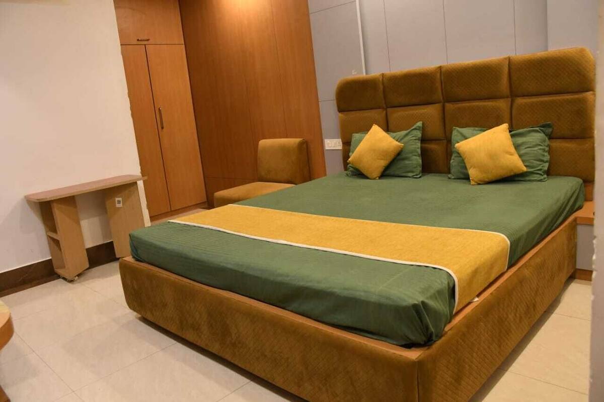 A bedroom with a bed, a nightstand, a chair, and a wardrobe.