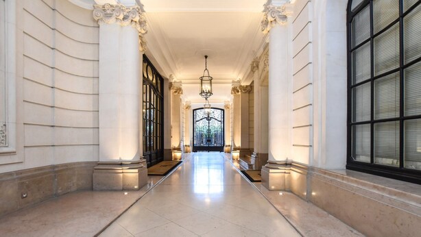 A grand hallway with marble floors, classical columns, and a large arched window. - Bright Studio - 2P - Arc de Triomphe (Paris)