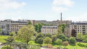 A park with trees and a building in the background. - Bright Studio - 2P - Arc de Triomphe (Paris)