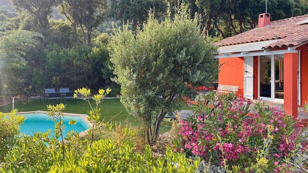 A pool with a red building in the background. - Lou Tavan - Villa 4 Chambres - Piscine & Jacuzzi (Le Lavandou)