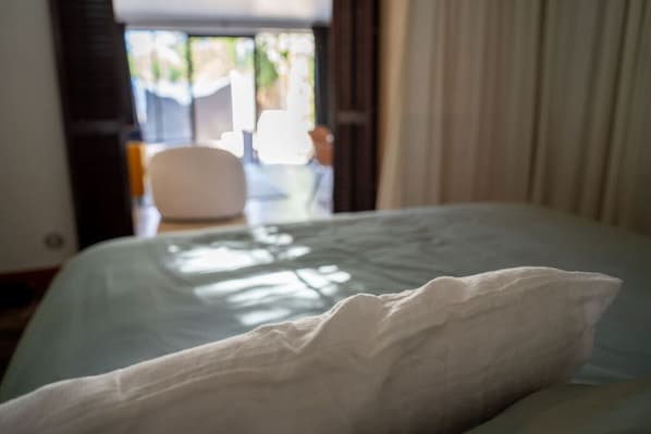 Ein Hotelzimmer mit Bett, Stuhl und Blick ins Freie.