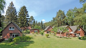 A row of brick houses with a well-maintained lawn and trees in the background. - Seepark Heidenholz, Plau am See (Plau am See)