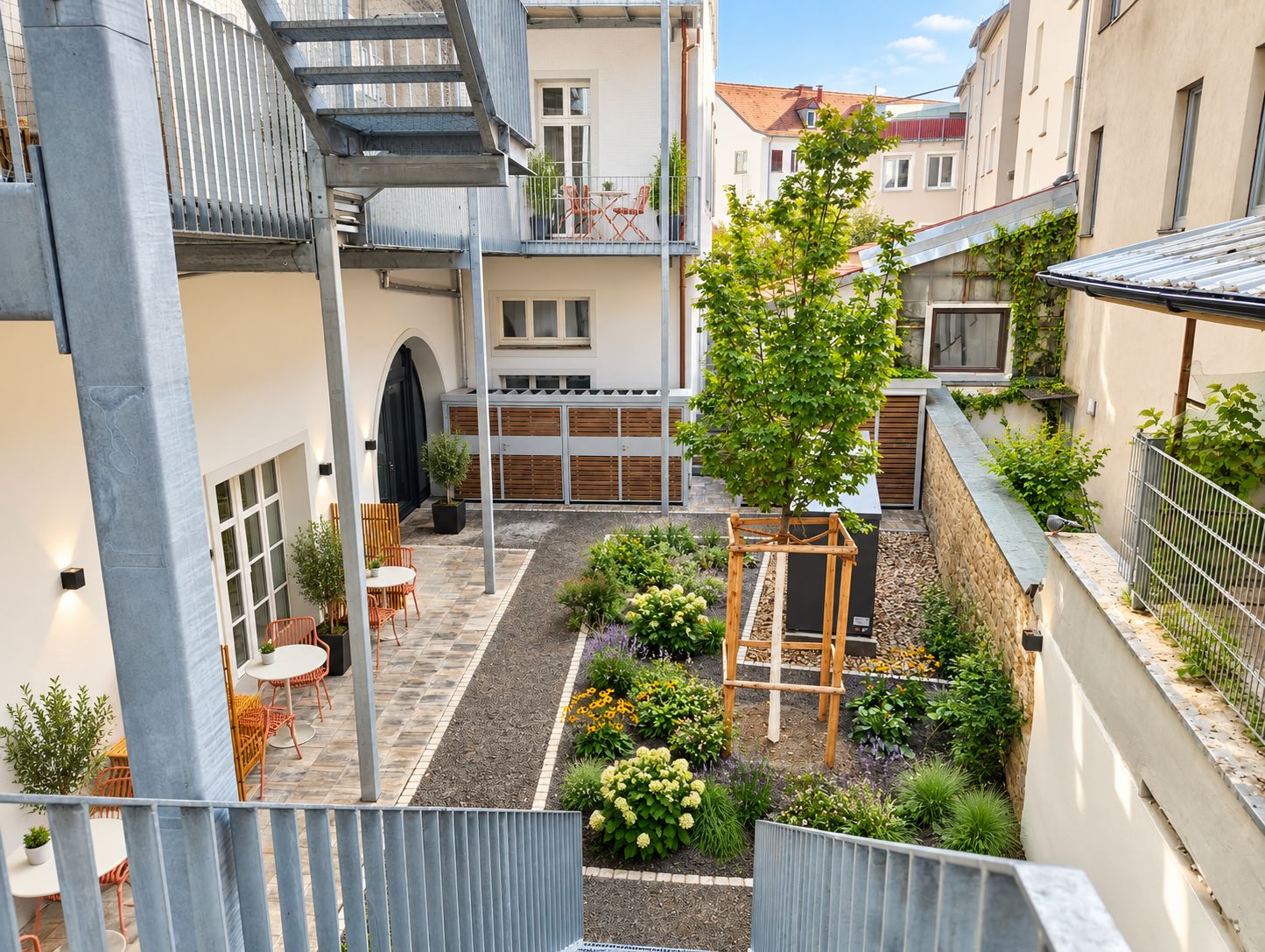 A courtyard with a wooden pergola, outdoor seating, and a variety of plants.