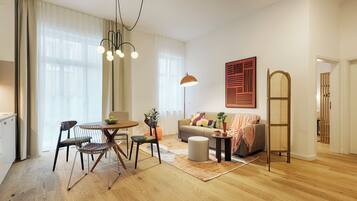 A modern living room with a dining area, a sofa, a coffee table, and a floor lamp.