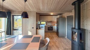 A modern kitchen with a central island, a built-in stove, and wooden flooring. - 2 bedroom beautiful home in Gålå (Gålå)