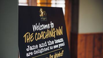 A welcome sign for The Coaching Inn with text inviting guests and mentioning a person named Jane.
