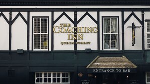 A building with a sign reading "The Coaching Inn Queen Street" and an entrance labeled "Entrance to Bar". - Coaching Inn (South Molton)