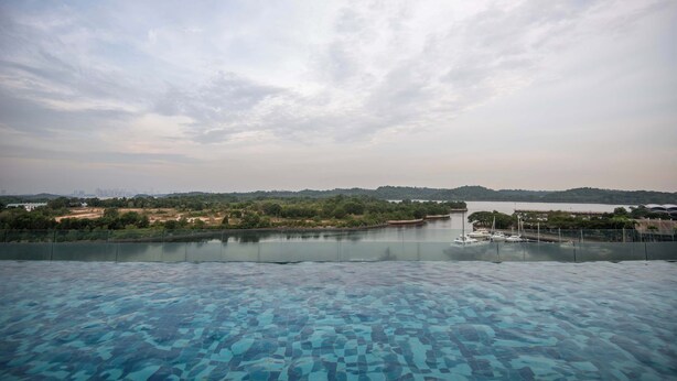 Vista despejada de una piscina con un río y colinas distantes al fondo.