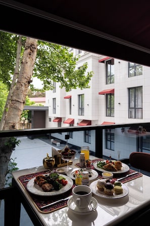 A dining table with plates of food, a cup of coffee, and a glass of juice. - Marhaba Hotel & Spa (Tashkent)