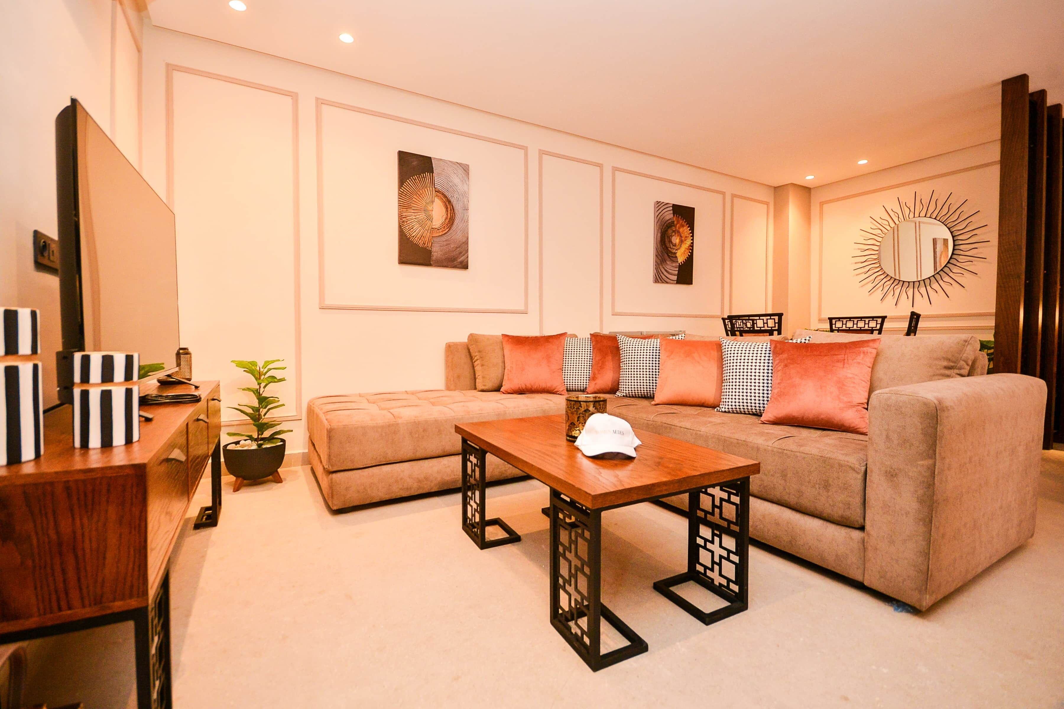 A living room with a sofa, a coffee table, and a decorative mirror.