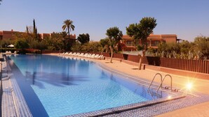 A swimming pool with lounge chairs and a sunlit poolside area. - Palmeraie Stay - Pool & Lake (Marrakesh)