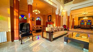 A spacious lobby with a grand chandelier, a reception desk, and a seating area with a sofa and armchairs. - Charming Luxury Villa | Pool & Hot Tub (Marrakesh)