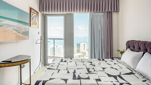 A modern hotel room with a large bed, a view of the city, and a balcony with curtains. - High-Rise Sea-View Stay by Sea N' Rent (Tel Aviv)