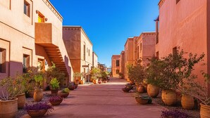 A narrow street lined with buildings and potted plants. - Waky Club | Designer Flat (Aghouatim)