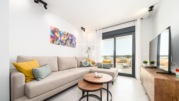 A modern living room with a sofa, a coffee table, and a TV on a wooden cabinet. - Cobalt Canvas Residence, by OYOOSTAYS (Mil Palmeras)