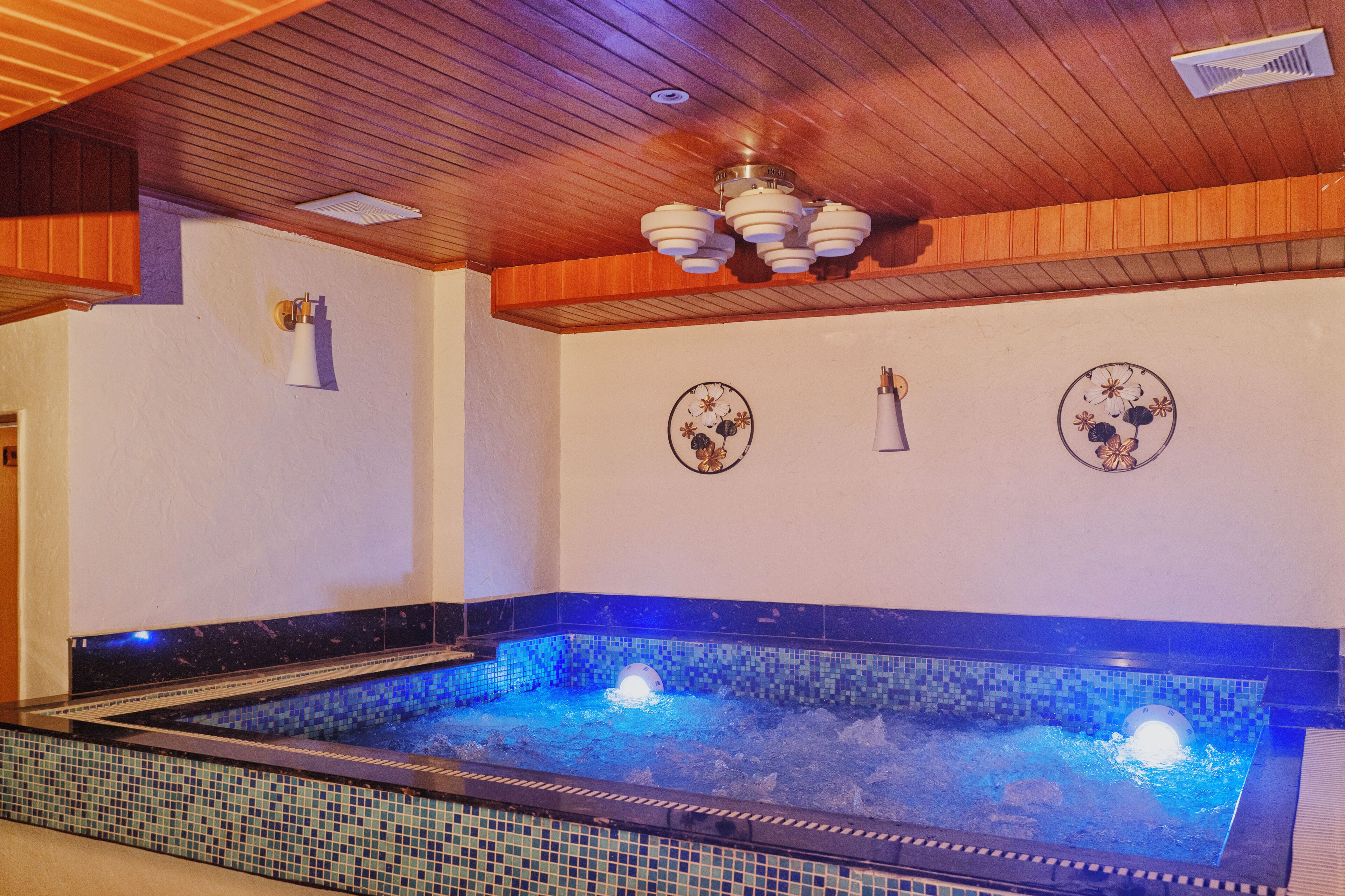 A spa area with a tiled floor, a ceiling fan, and decorative wall art.