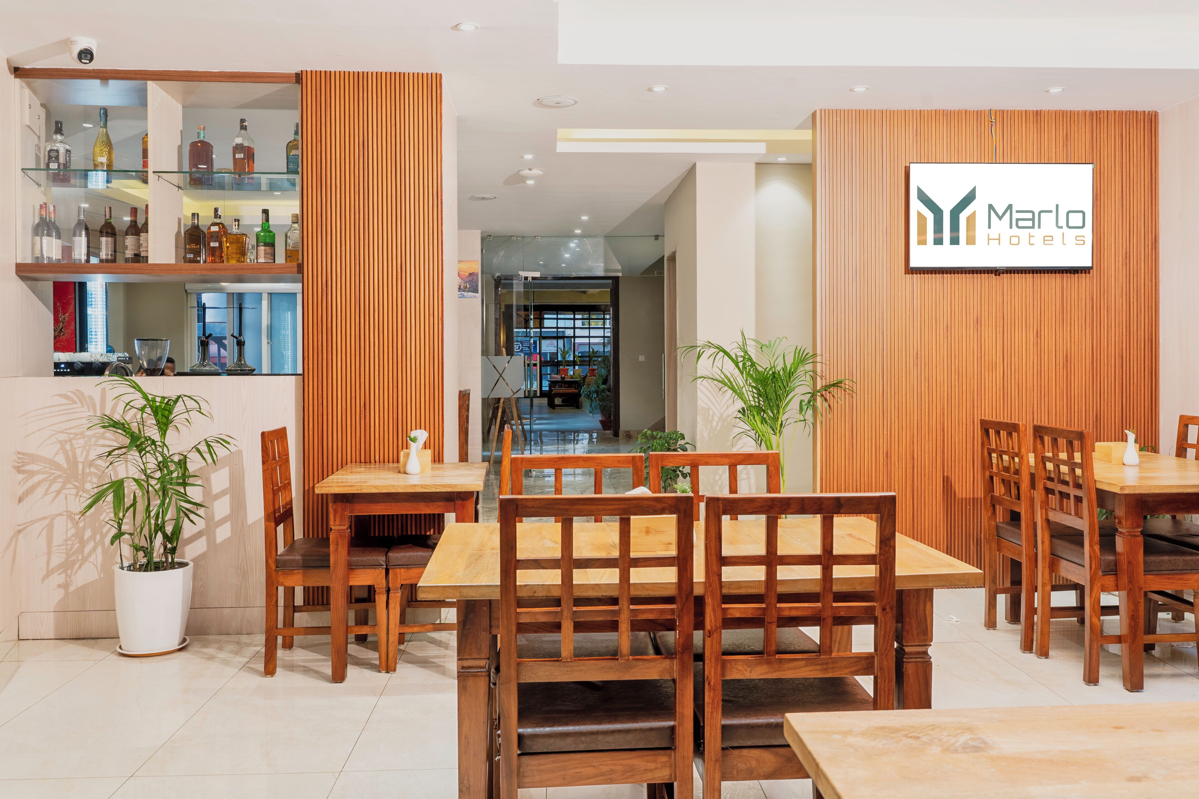 A hotel lobby with wooden paneling, a reception desk, and a bar area with liquor bottles.