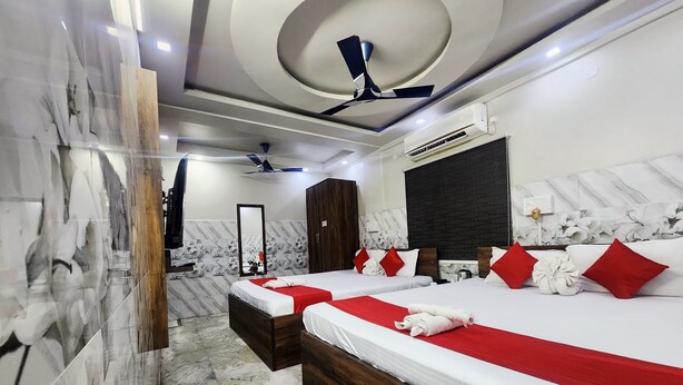 A hotel room with two beds, a ceiling fan, an air conditioning unit, and a marble floor. - Anandaloke Residency (Kolkata)